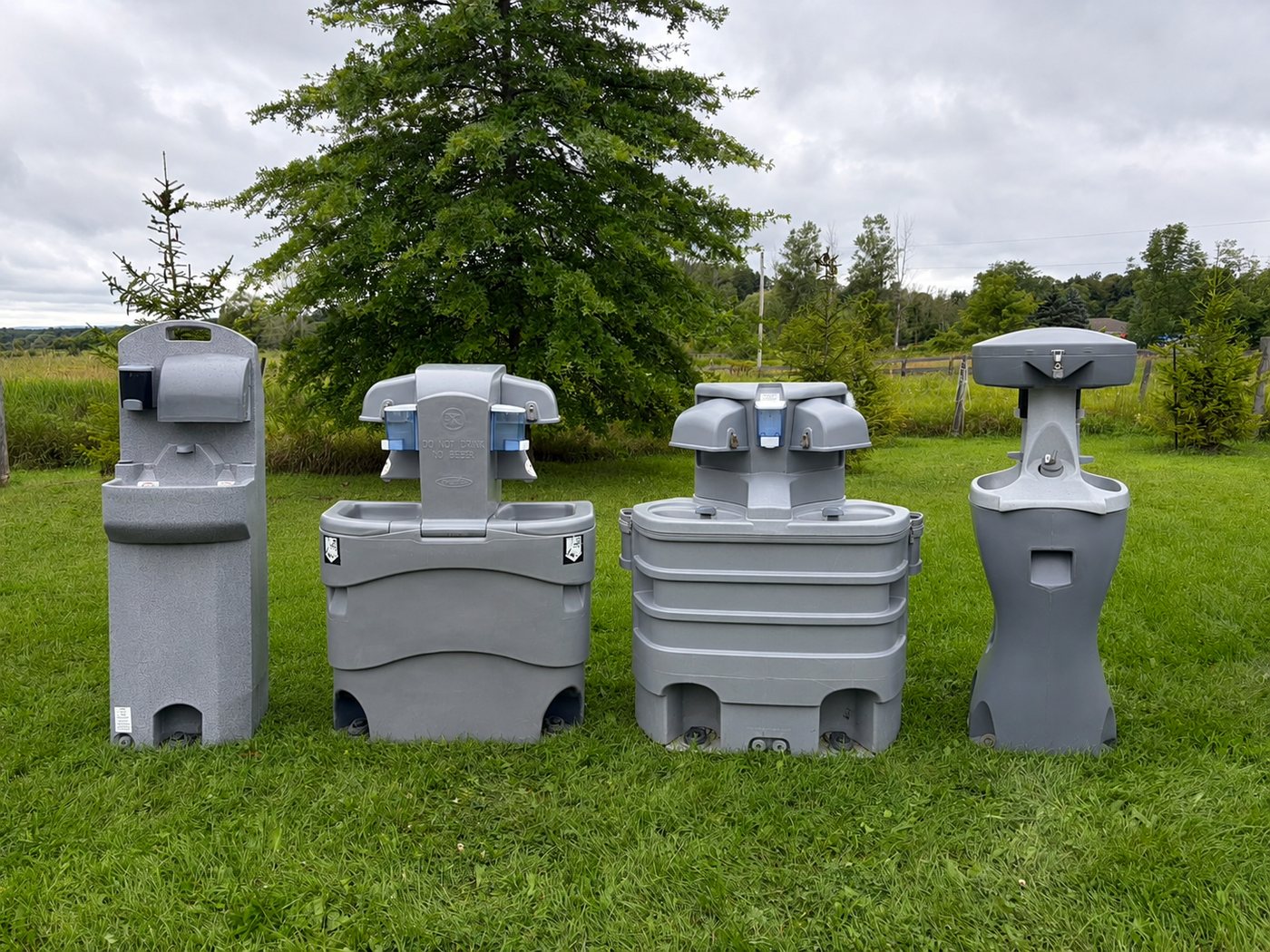 Lineup of four portable hand wash station models